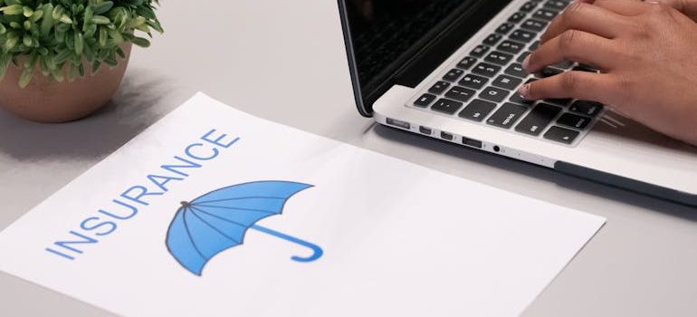 A Paper beside a Person Typing on a Laptop