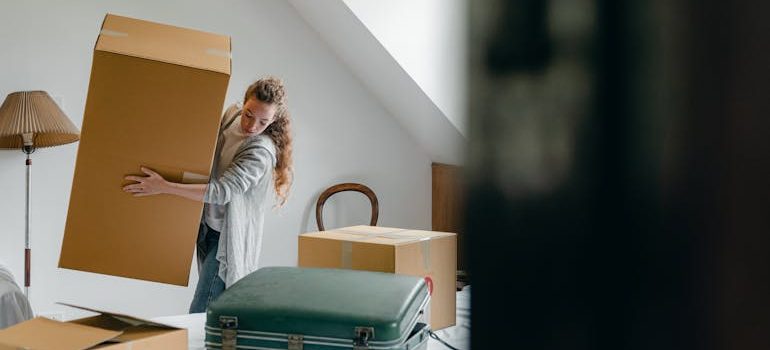 Woman carrying boxes in new apartment